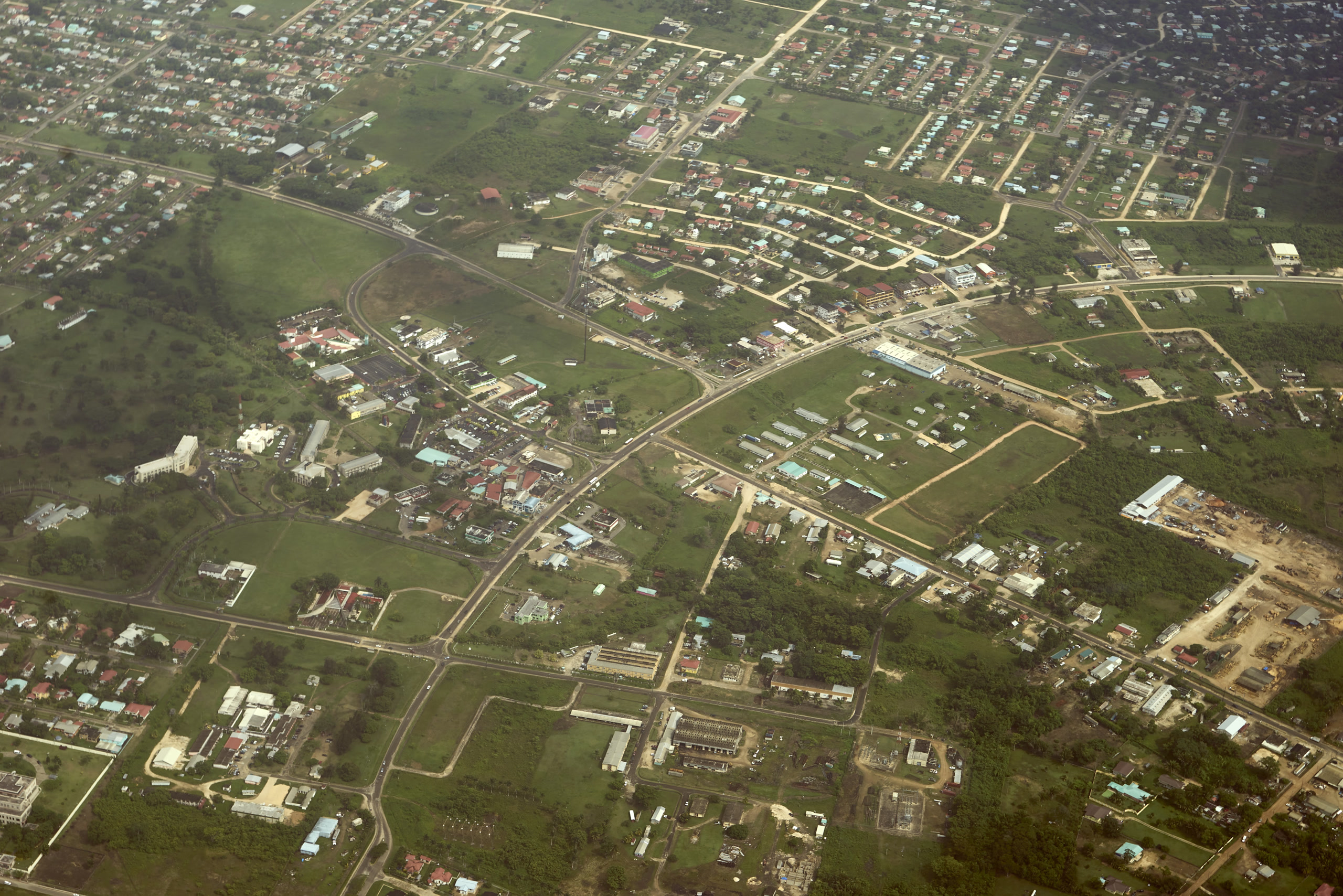 Aerial of Belmopan's grid of streets and houses from a plane window; low quality, Belize has few cityscape photos. Belize, Offshore BPO Confidence Index 2023