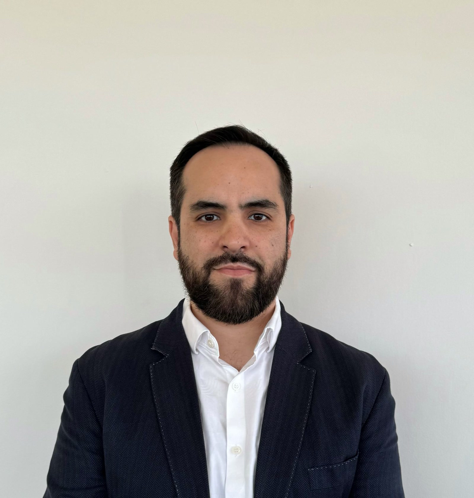 Daniel Castilla, Co-Founder and Managing Director, Alliance BPO Services, Mexico, Offshore BPO Confidence Index 2024: Man with a full beard in a navy blazer and white open-collar shirt against a plain wall