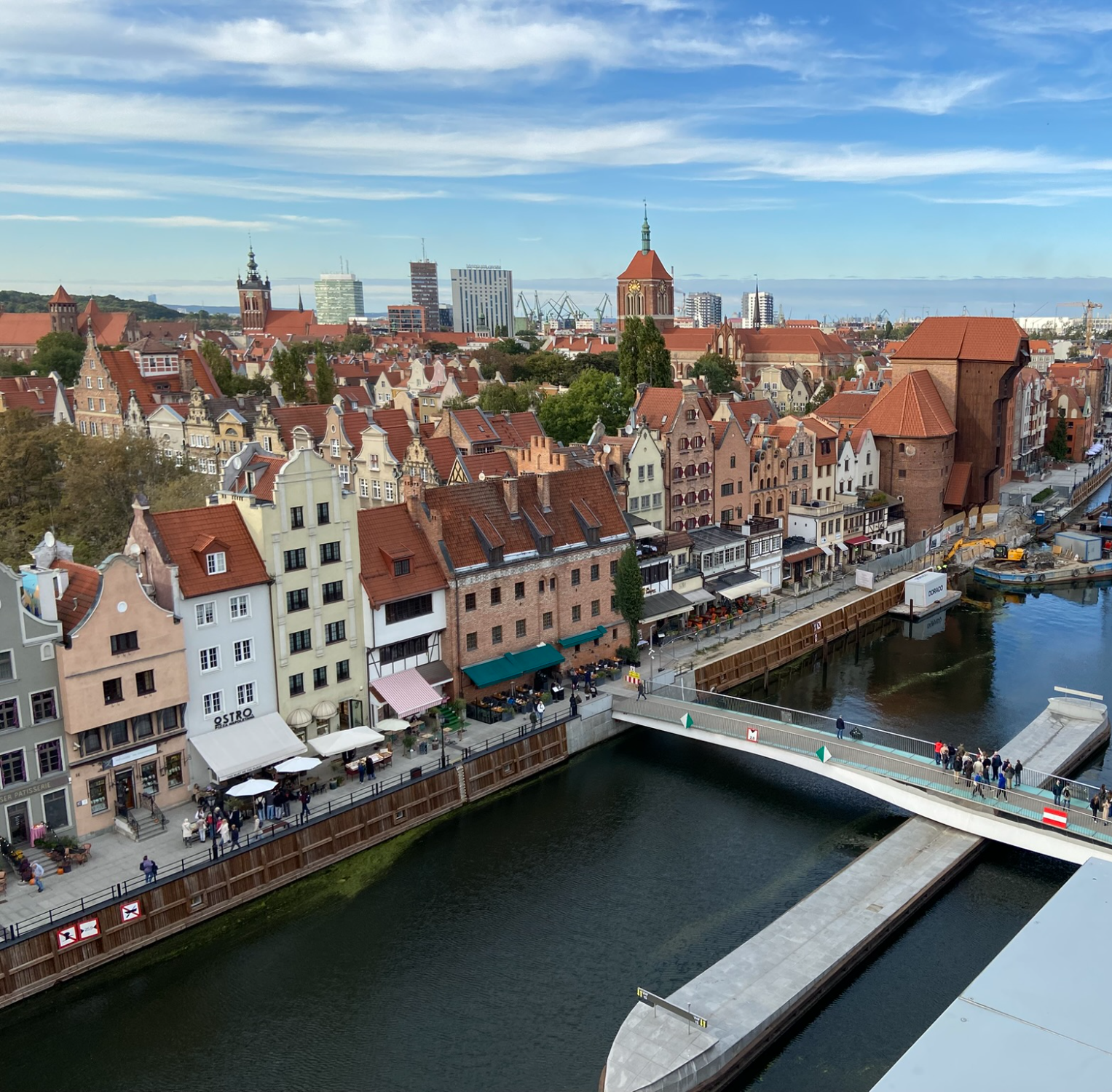 Aerial view of Gdansk, Poland with gabled brick townhouses, a riverside promenade, and a footbridge over the river. Poland, Offshore BPO Confidence Index 2024
