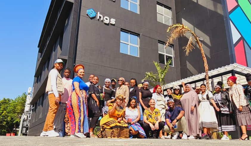 HGS South Africa team, Offshore BPO Confidence Index 2024: About twenty people in a mix of traditional and business dress outside an office building marked HGS
