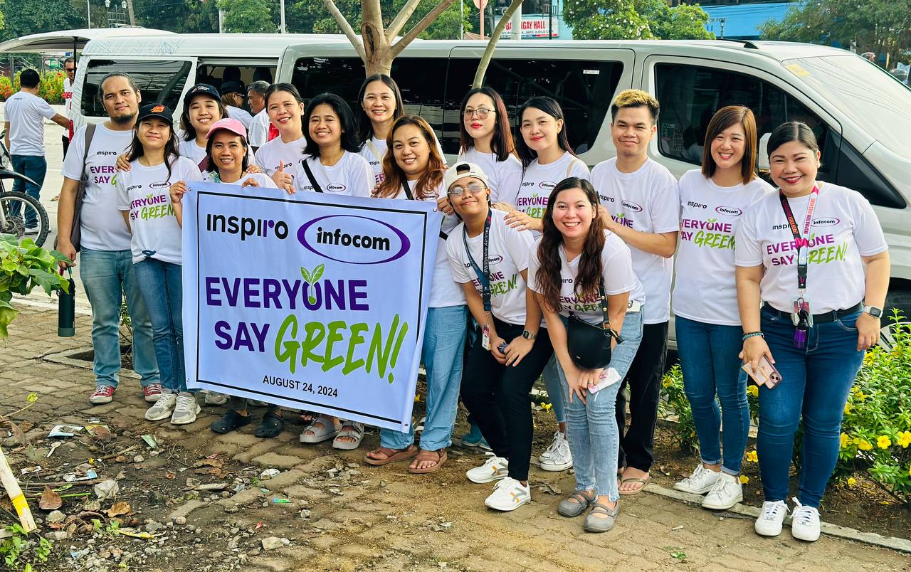 Inspiro Philippines team, Offshore BPO Confidence Index 2024: About fifteen people in white Everyone Say Green shirts holding a banner outdoors beside a van