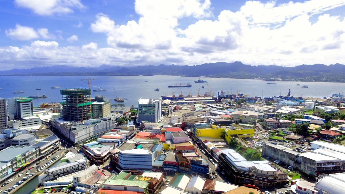 Aerial view of Suva, Fiji with a harbor full of cargo ships, city buildings, and mountains beyond. Fiji, Offshore BPO Confidence Index 2024