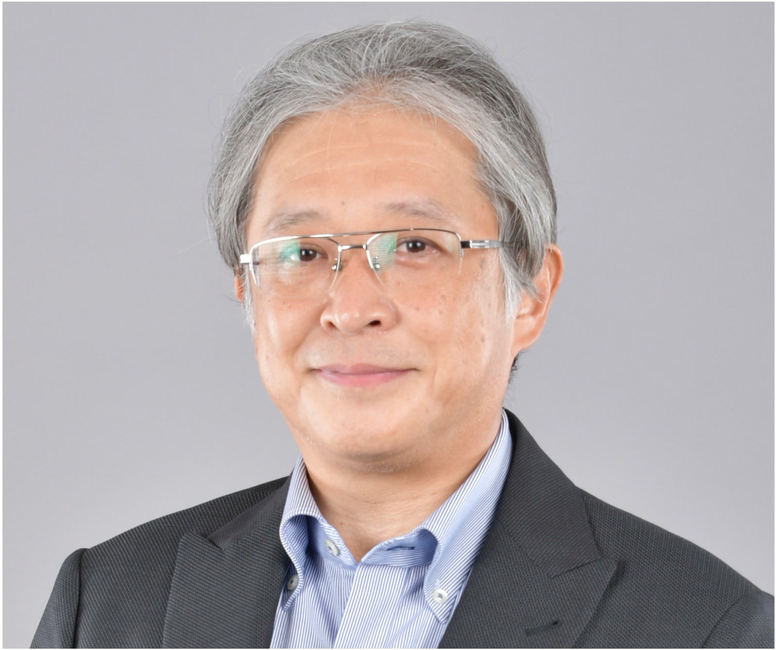 Yuji Hamamoto, President and CEO, Inspiro Philippines, Offshore BPO Confidence Index 2024: Smiling man with gray hair and half-rim glasses in a dark suit against a gray background