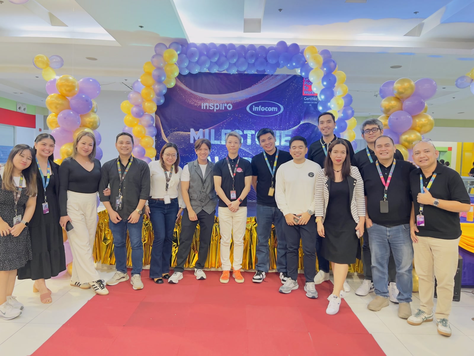 Altius Inspiro team in Philippines, Offshore CX Confidence Index 2025: About fourteen employees pose on a red carpet in front of a purple and gold balloon arch indoors