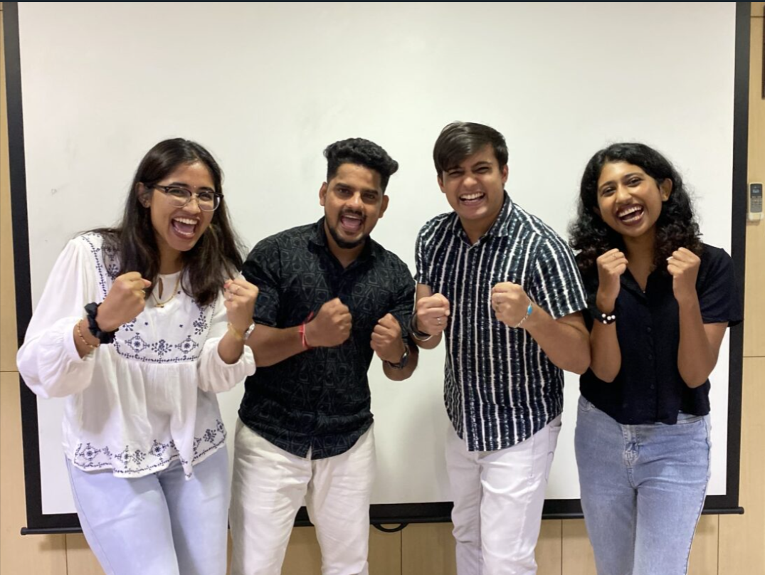 UnifyCX team in India, Offshore CX Confidence Index 2025: Four young adults cheering with raised fists in front of a large whiteboard